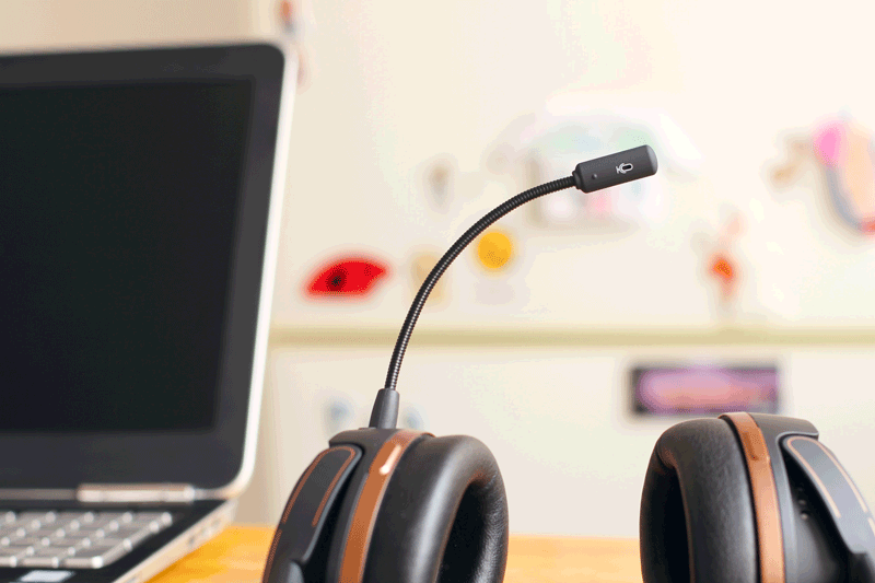 Ein Headset liegt neben einem Laptop in einem Büro